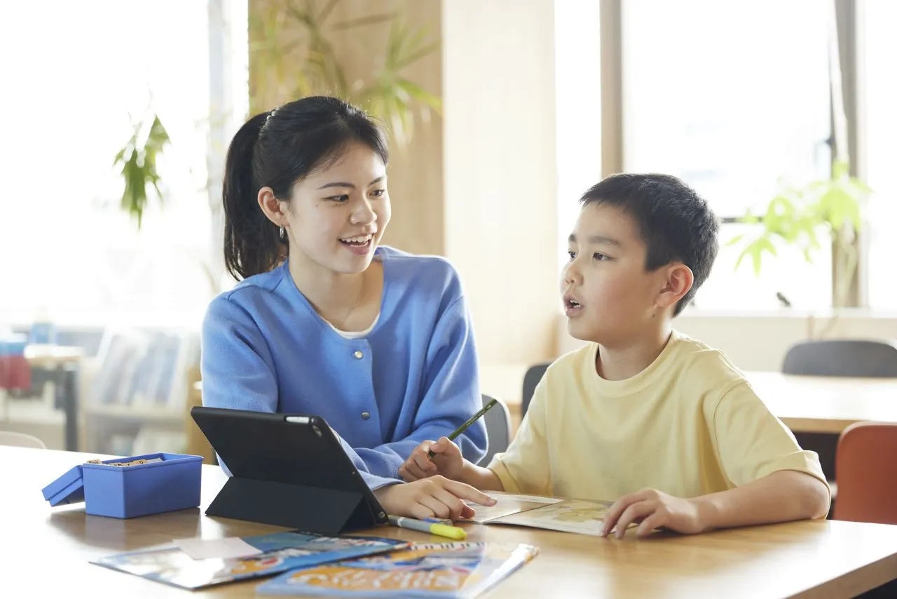 バイリンガル教師と英語で会話する小学生